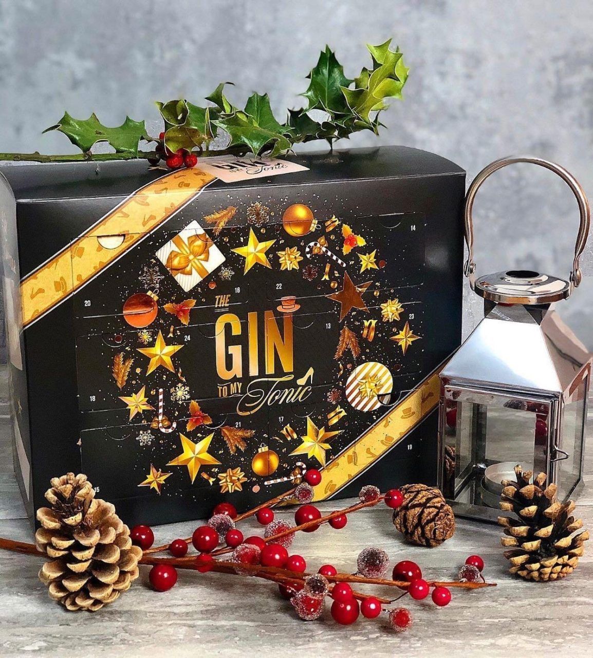 The Gin To My Tonic Christmas Advent Calendar with festive accessories on a sparkly background