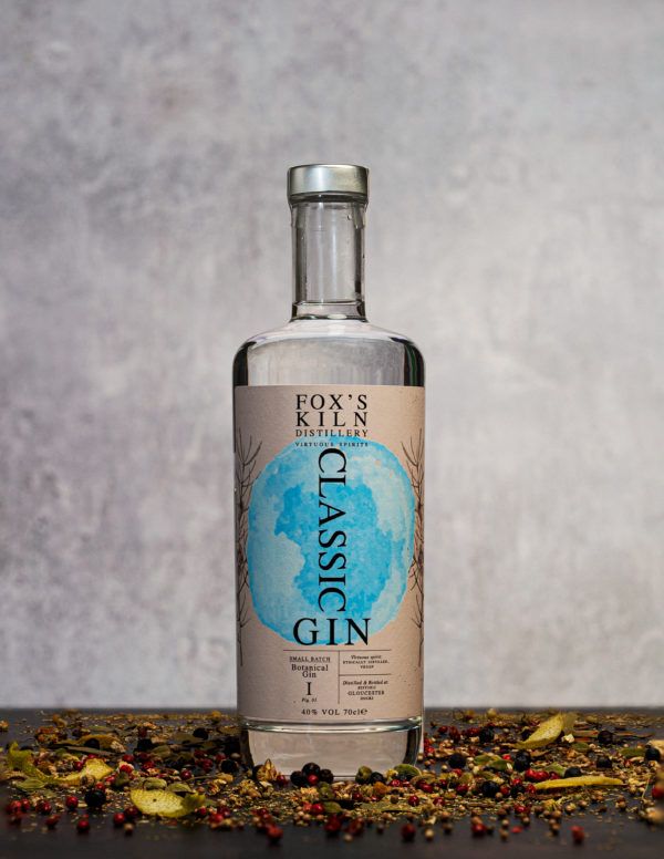 Fox's Kiln Classic Gin 70cl on grey background surrounded by botanicals